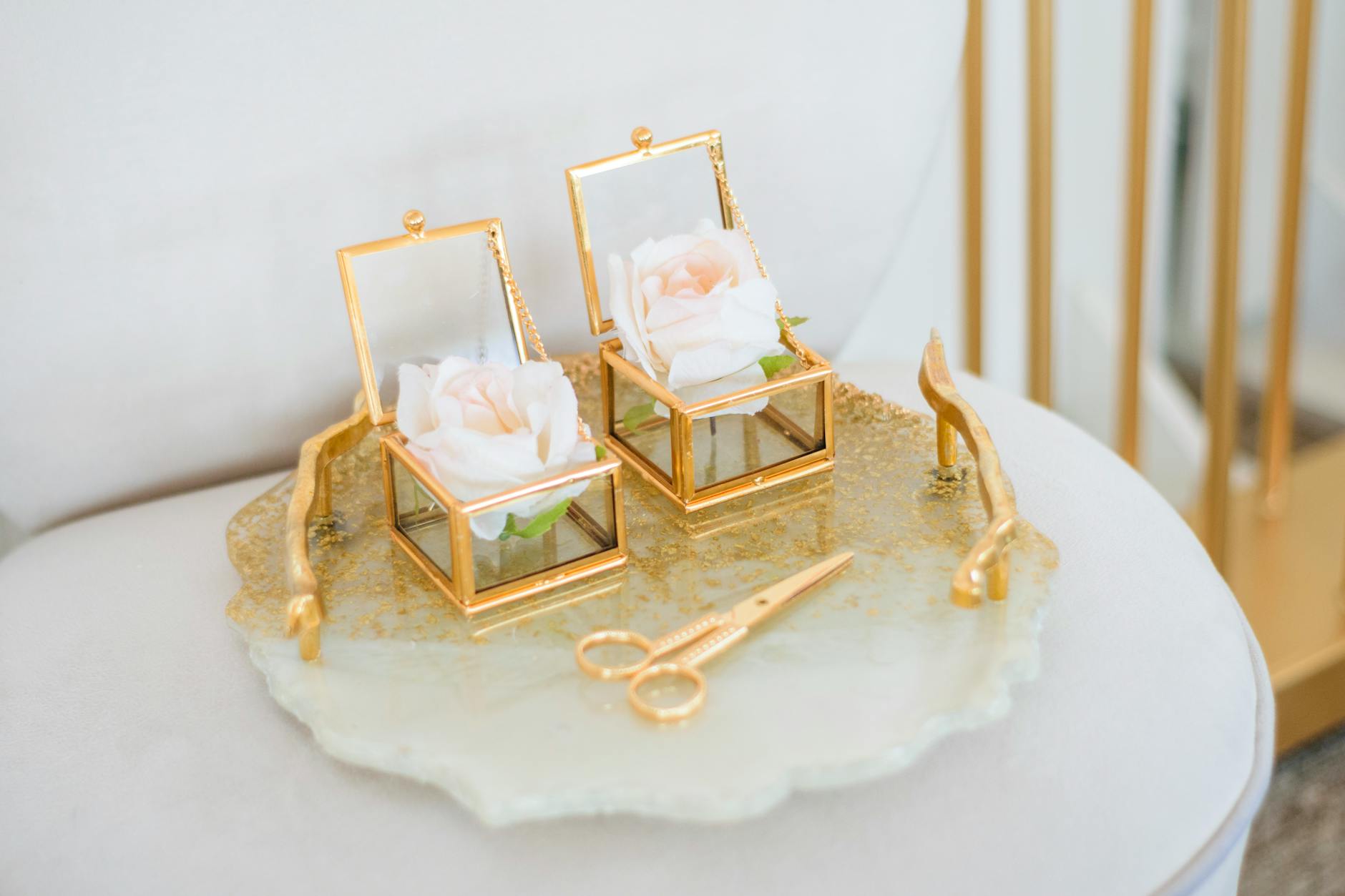 Złote szklane szkatułki z różami na tacy jako dekoracja ślubna
